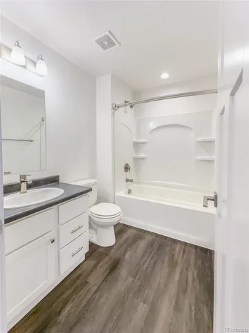 a bathroom with a double vanity sink toilet mirror and bathtub