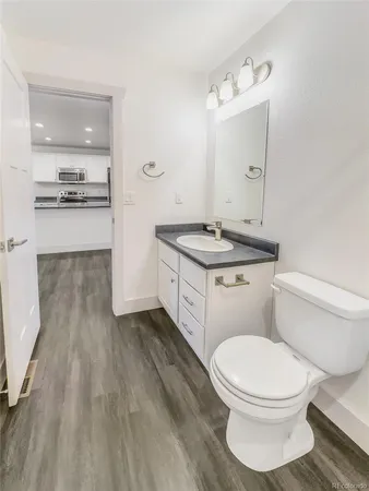 a bathroom with a granite countertop toilet sink and mirror