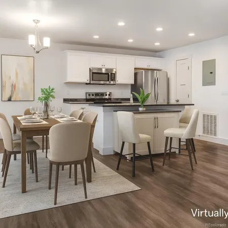 a kitchen with stainless steel appliances a dining table chairs stove refrigerator and cabinets