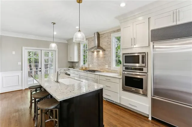 a kitchen with granite countertop a sink cabinets and stainless steel appliances