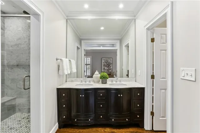 a bathroom with a granite countertop sink a mirror and a shower