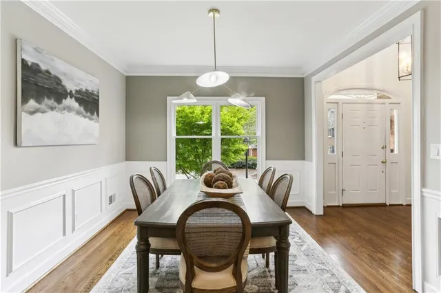 a dining room with furniture a chandelier and wooden floor