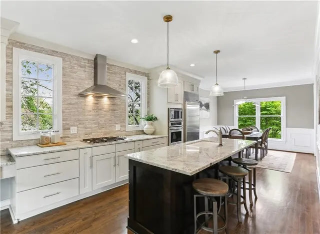 a kitchen with a table chairs sink and wooden floor
