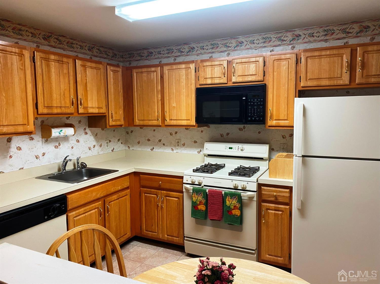 340 Bowler Court Piscataway, NJ 08854 - Photo 4 of 23 a kitchen with stainless steel appliances granite countertop a sink stove refrigerator and a microwave oven
