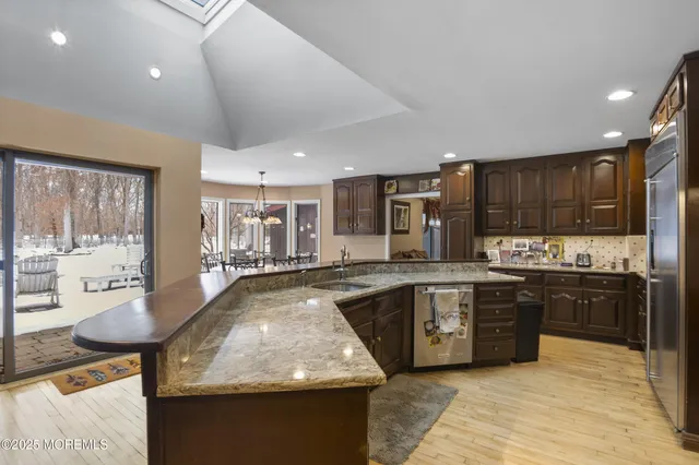 a large kitchen with granite countertop lots of counter top space and stainless steel appliances