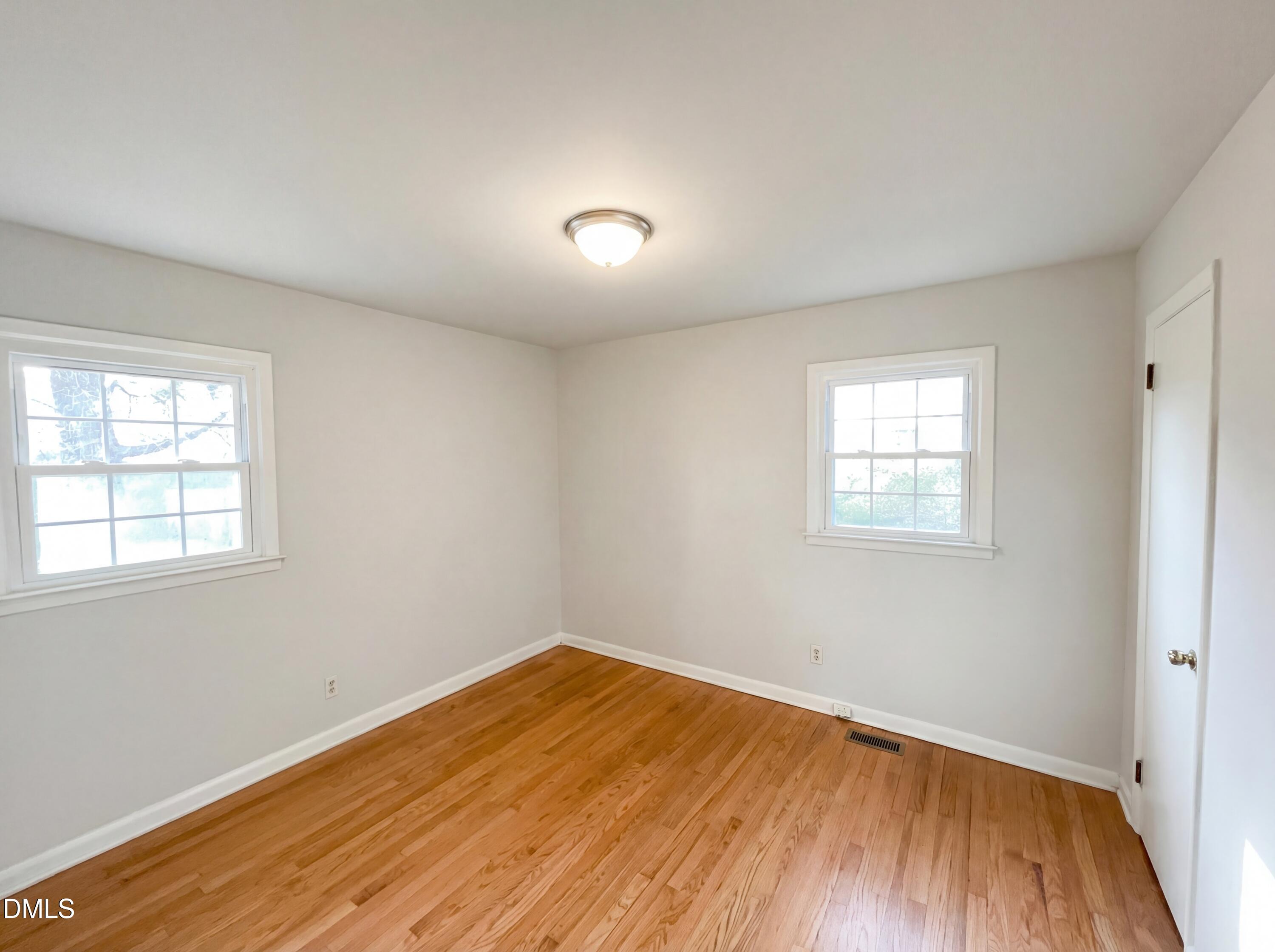 6412 Rock Quarry Road Raleigh, NC 27610 - Photo 11 of 17 an empty room with wooden floor and windows