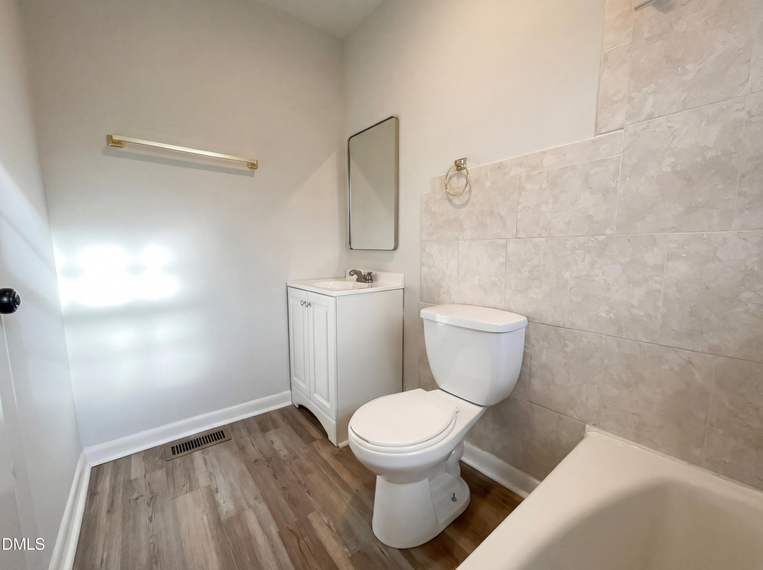 6412 Rock Quarry Road Raleigh, NC 27610 - Photo 14 of 17 a white toilet sitting next to a bathroom sink and vanity