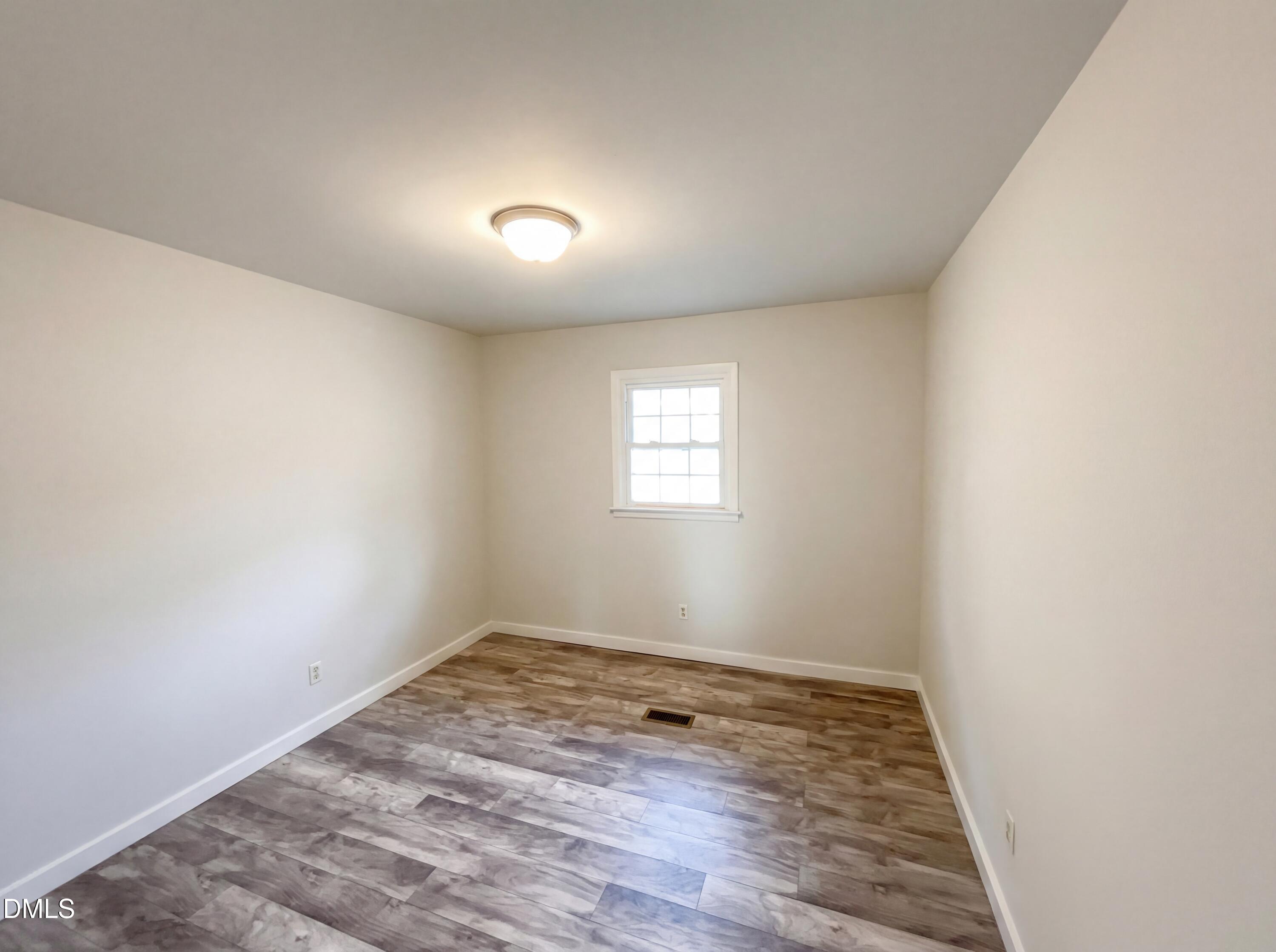 6412 Rock Quarry Road Raleigh, NC 27610 - Photo 9 of 17 an empty room with wooden floor and windows