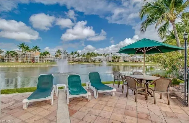 a view of a chairs and table in patio with a lake view