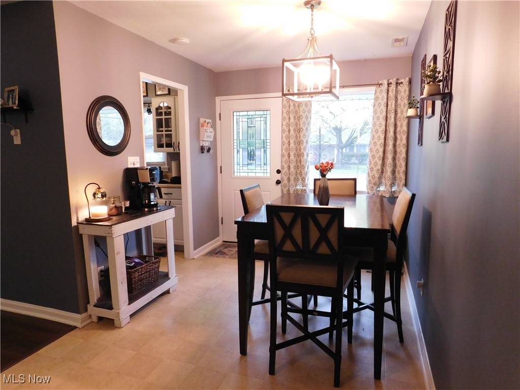 9720 West Ridgewood Drive Parma Heights, OH 44130 - Photo 6 of 46 Dining area with light floors, a notable chandelier, and front door access