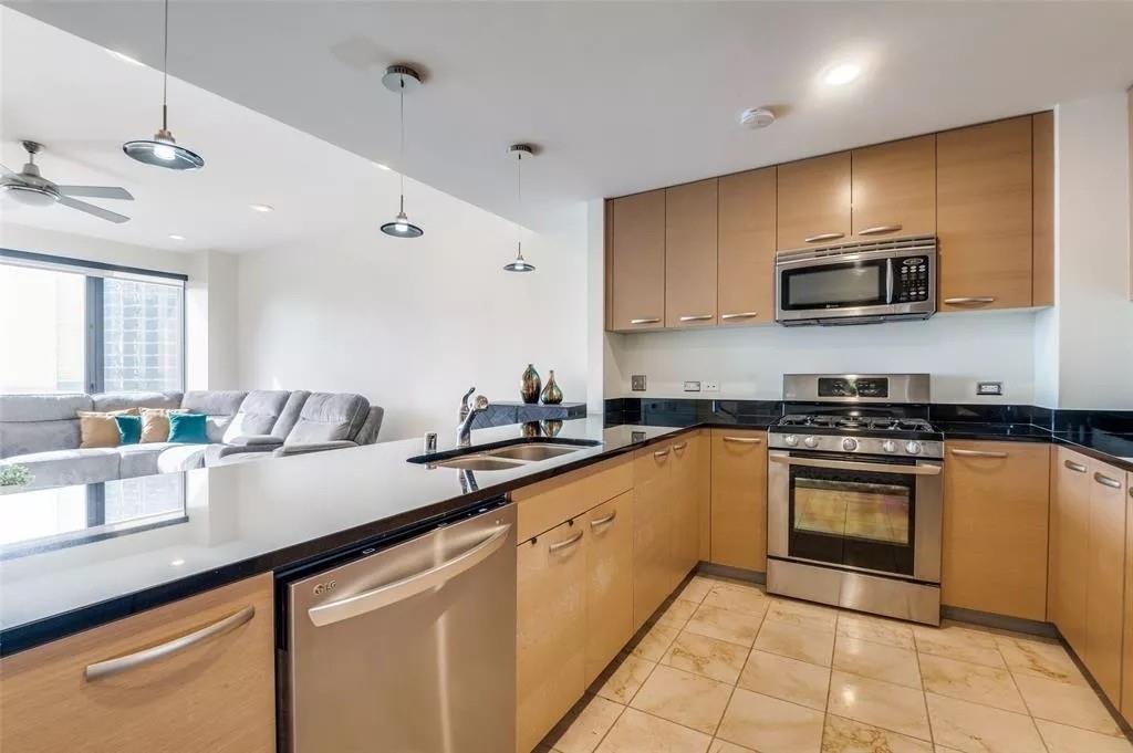 1200 Main Street, Unit 1404 Dallas, TX 75202 - Photo 25 of 26 a kitchen with stainless steel appliances granite countertop a sink counter space cabinets and a stove
