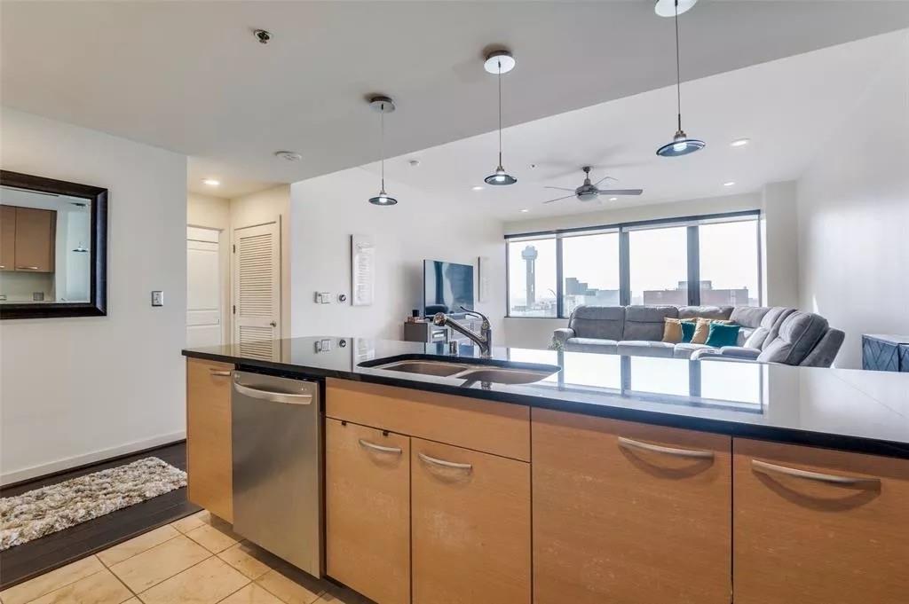 1200 Main Street, Unit 1404 Dallas, TX 75202 - Photo 27 of 27 a kitchen with granite countertop a sink and white cabinets