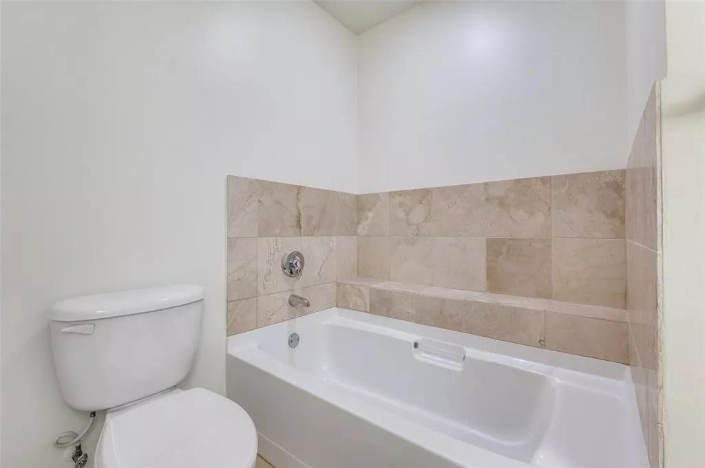 1200 Main Street, Unit 1404 Dallas, TX 75202 - Photo 13 of 26 a bathroom with a toilet a sink and bathtub