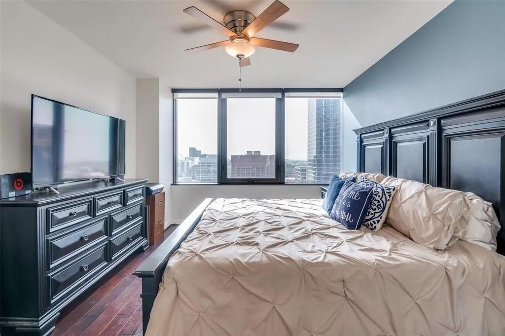 1200 Main Street, Unit 1404 Dallas, TX 75202 - Photo 18 of 27 a bedroom with a large bed and a flat tv screen on dresser
