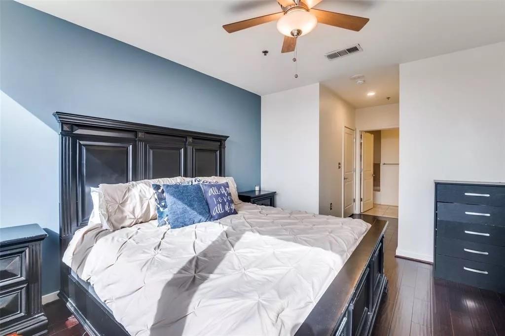 1200 Main Street, Unit 1404 Dallas, TX 75202 - Photo 19 of 27 a bedroom with a large bed and a chandelier