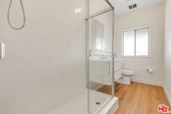 a bathroom with a granite countertop sink a toilet and shower