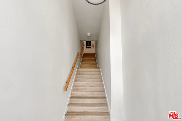 a view of a hallway with wooden floor and entryway