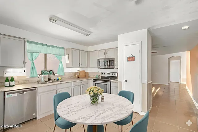 a kitchen with stainless steel appliances granite countertop a kitchen island a stove a table and chairs