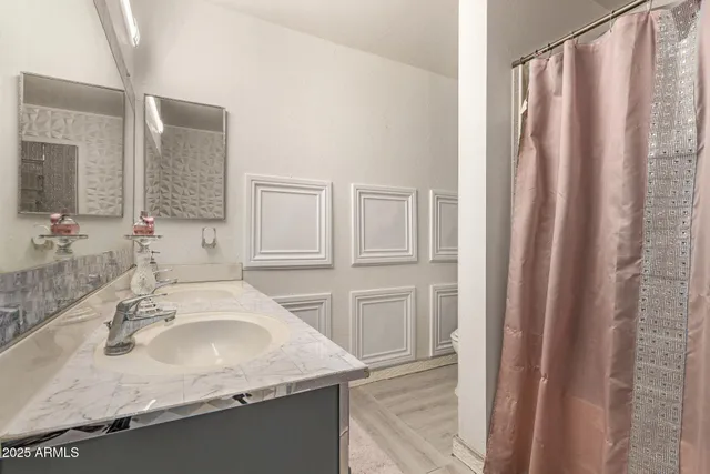 a bathroom with a granite countertop sink and a mirror