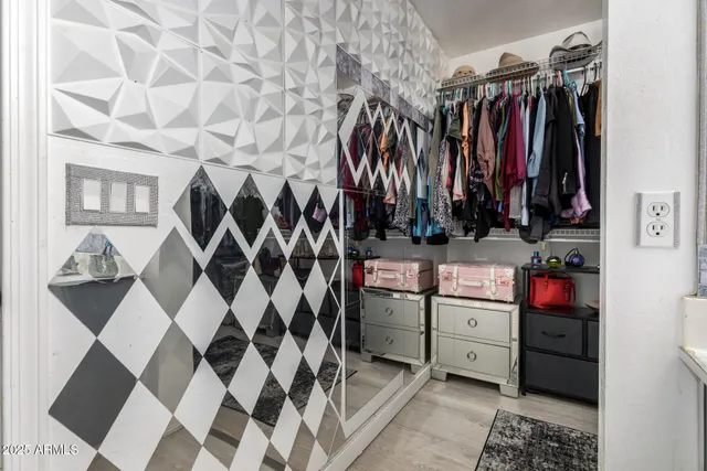 a view of walk in closet with clothes