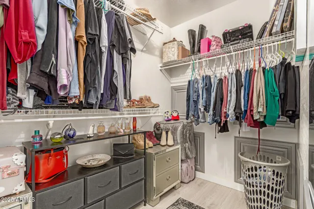 a view of walk in closet with clothes and shoes