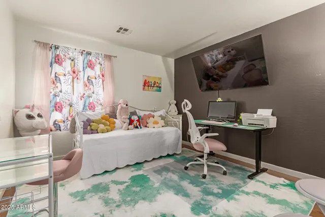 a living room with furniture and a painting on the wall