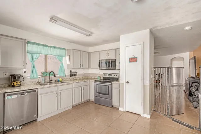 a kitchen with white cabinets and appliances