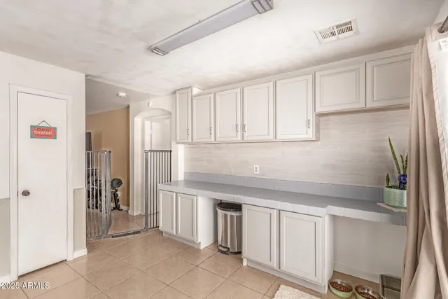 a kitchen with white cabinets and refrigerator