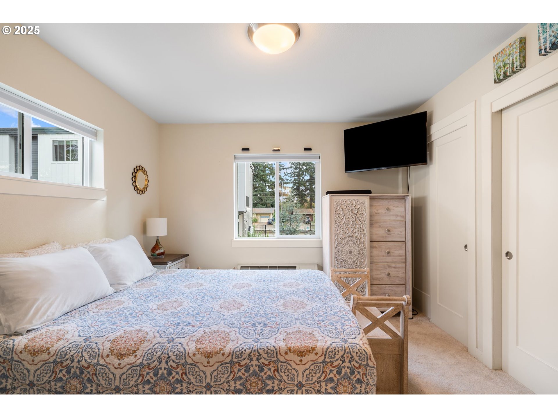 116 Northeast 109th Avenue, Unit A5 Portland, OR 97220 - Photo 29 of 46 a bedroom with a bed and a flat screen tv