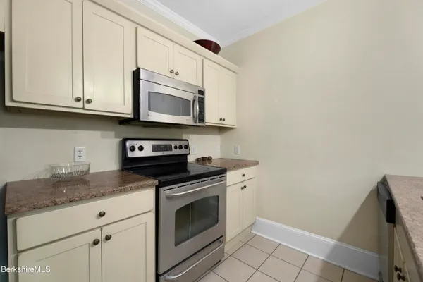 a kitchen with granite countertop white cabinets stainless steel appliances and a sink