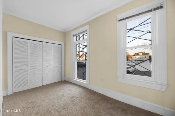 an empty room with windows and closet