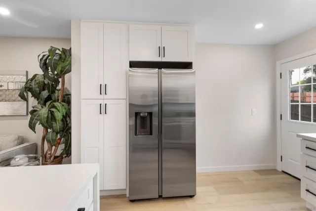 a kitchen with stainless steel appliances a refrigerator a sink and a potted plant