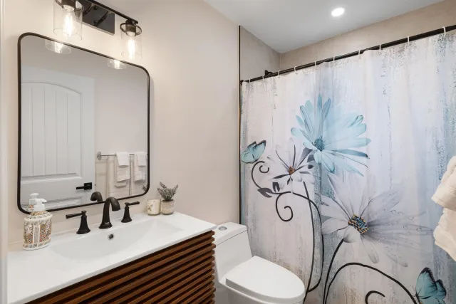 a bathroom with a sink and mirror with toilet