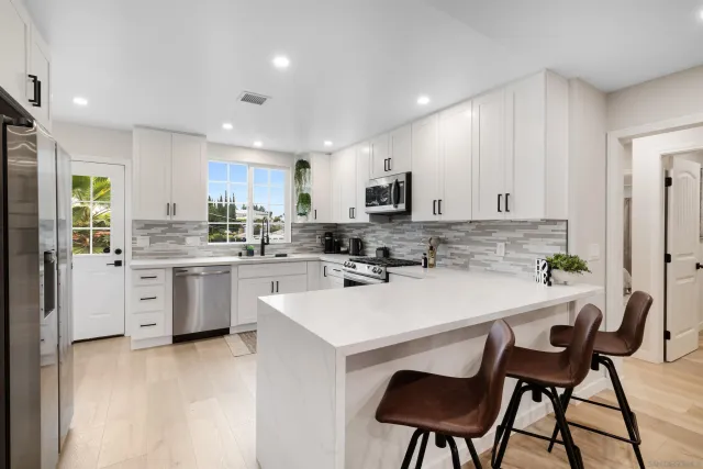 a kitchen with a sink stainless steel appliances and white cabinets