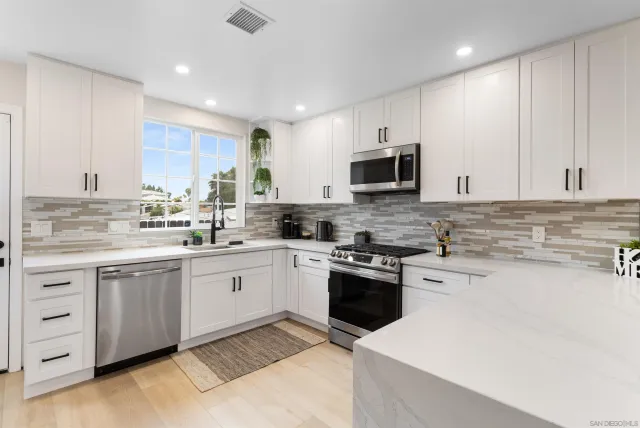 a kitchen with cabinets appliances a sink and a counter top space