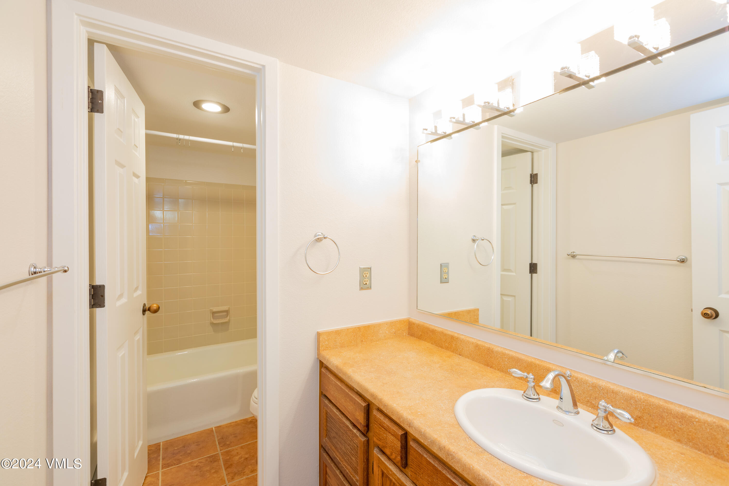 264 Eagle Drive, Unit 206 Eagle-Vail, CO 81620 - Photo 7 of 12 a bathroom with a granite countertop sink a mirror and a shower