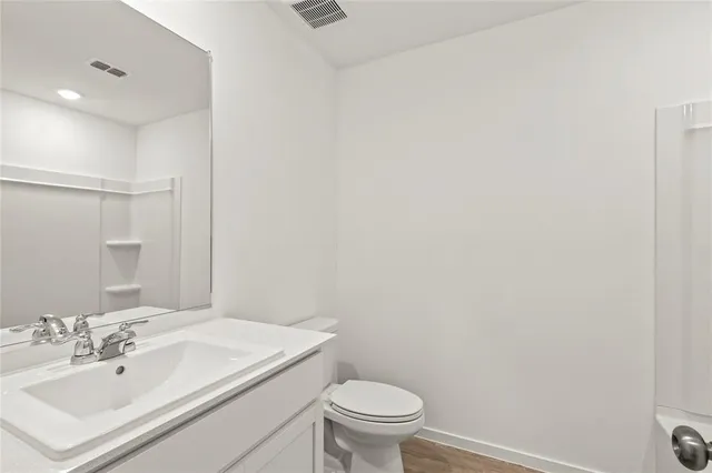 a bathroom with a sink a toilet and mirror