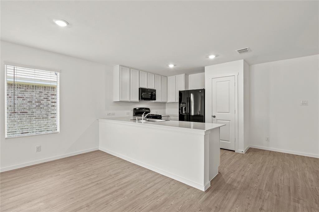 1138 Barbary Flds Street Forney, TX 75126 - Photo 8 of 19 a view of kitchen with microwave a refrigerator and a stove top oven