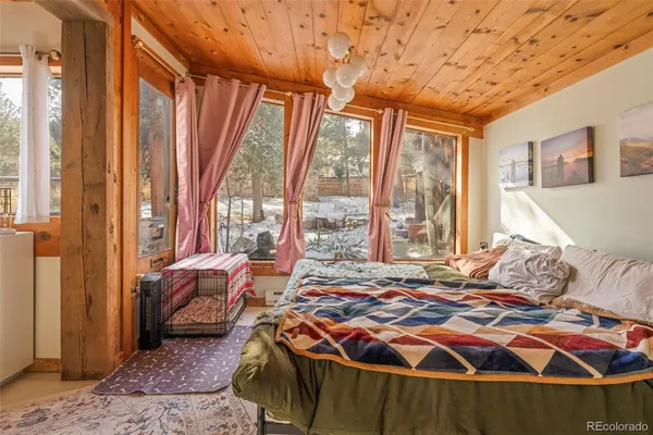 a bedroom with large window and a bed