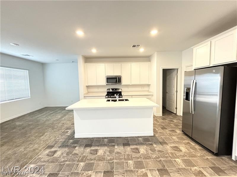 8336 Rowan Rdg Avenue Las Vegas, NV 89147 - Photo 3 of 15 This bright kitchen features an island, ample cabinetry, and sleek stainless steel appliances.