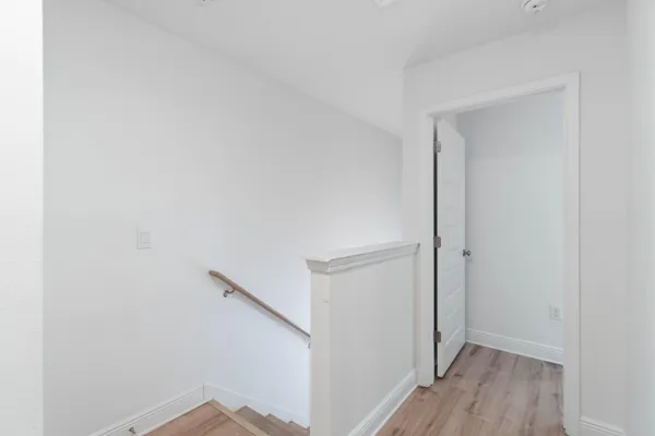 a view of hallway with wooden floor