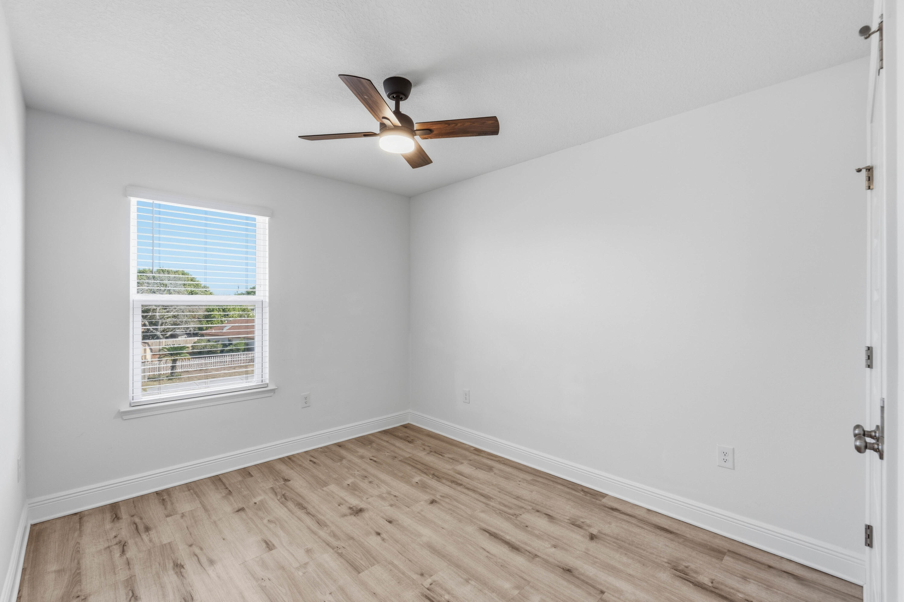 7 Renea Cove Destin, FL 32541 - Photo 18 of 36 an empty room with wooden floor ceiling fan and windows