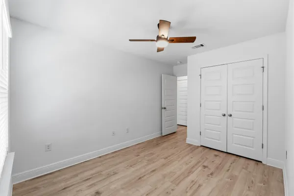 a view of empty room with wooden floor