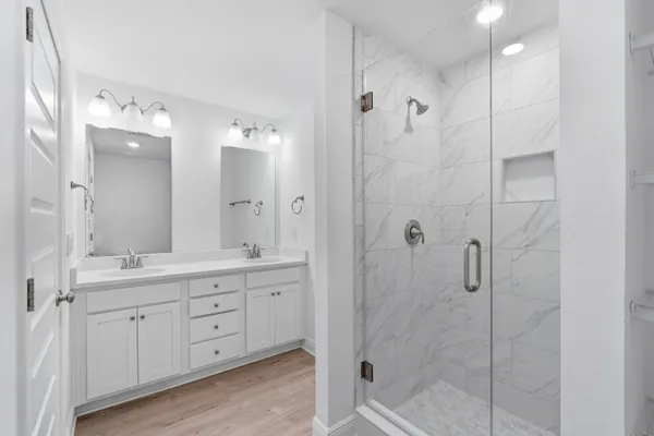 a bathroom with a shower sink and mirror