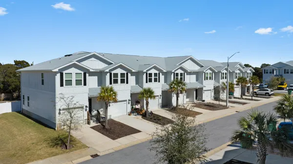 a front view of a residential houses with yard and mountain view