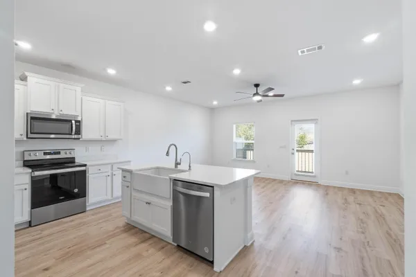 a view of a kitchen with a sink stove and wooden floor