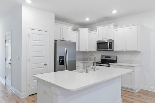 a kitchen with kitchen island a sink appliances and cabinets