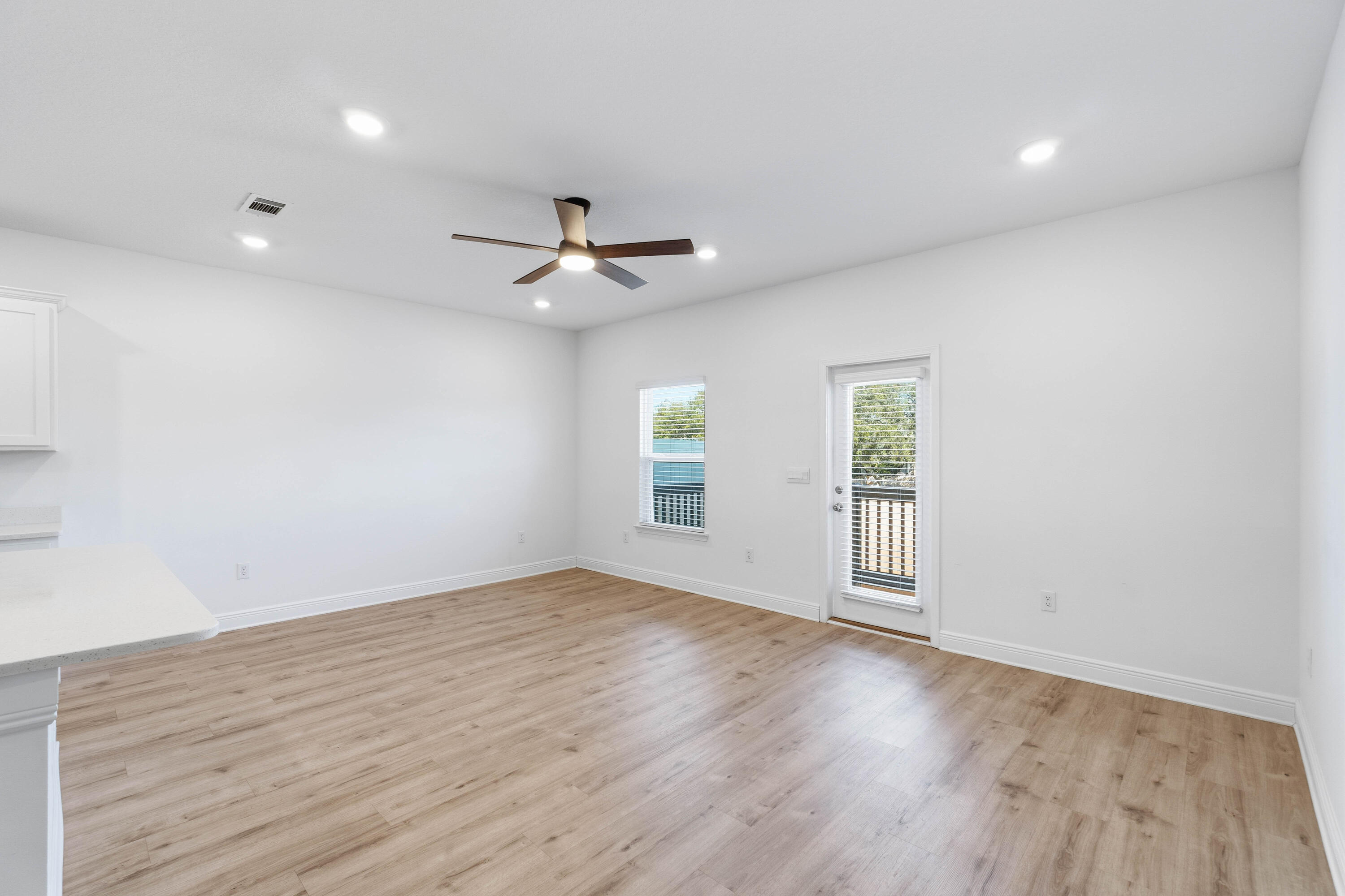 7 Renea Cove Destin, FL 32541 - Photo 8 of 36 an empty room with wooden floor ceiling fan and windows