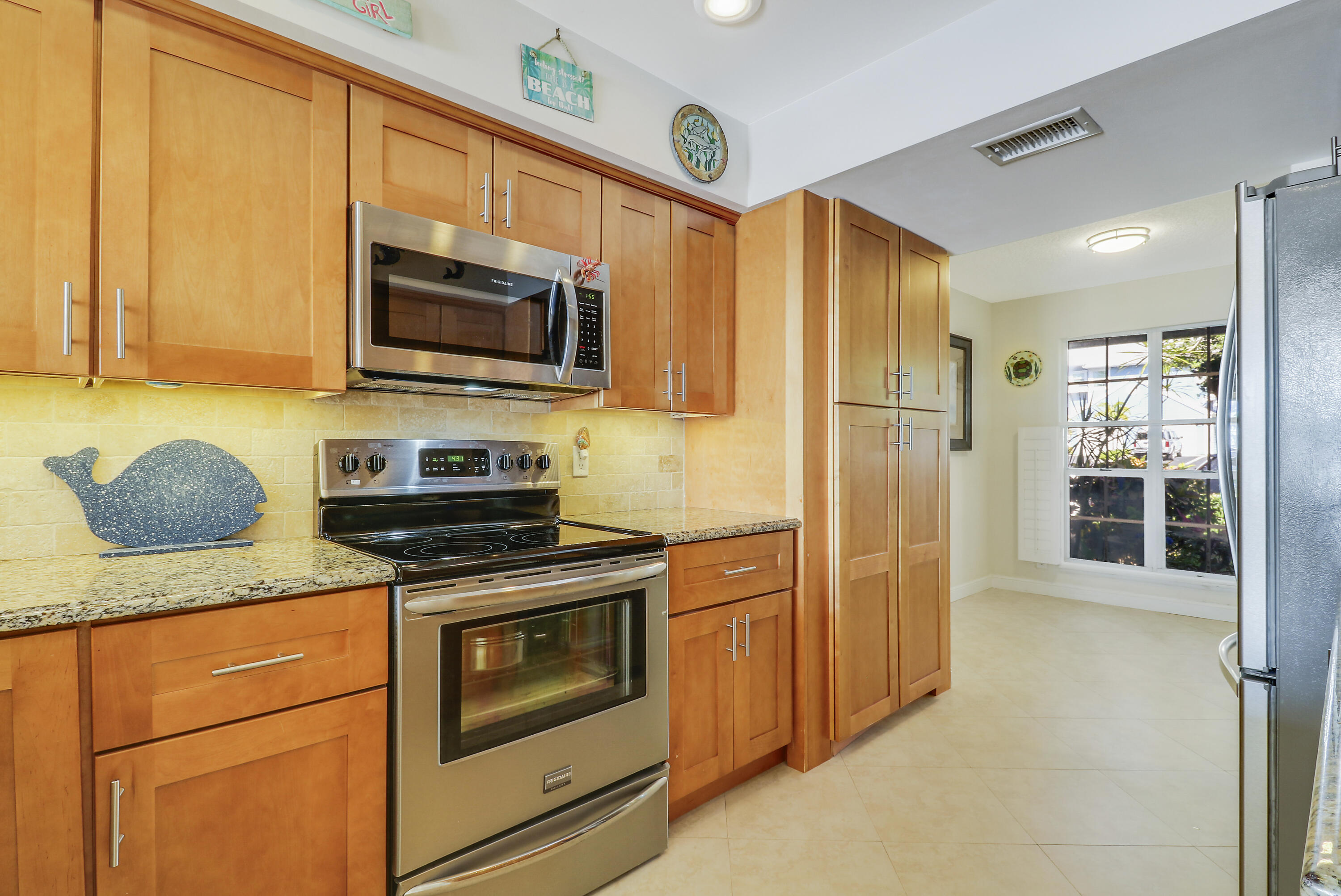213 Ocean Dunes Circle Jupiter, FL 33477 - Photo 18 of 46 a kitchen with stainless steel appliances granite countertop a stove microwave and refrigerator