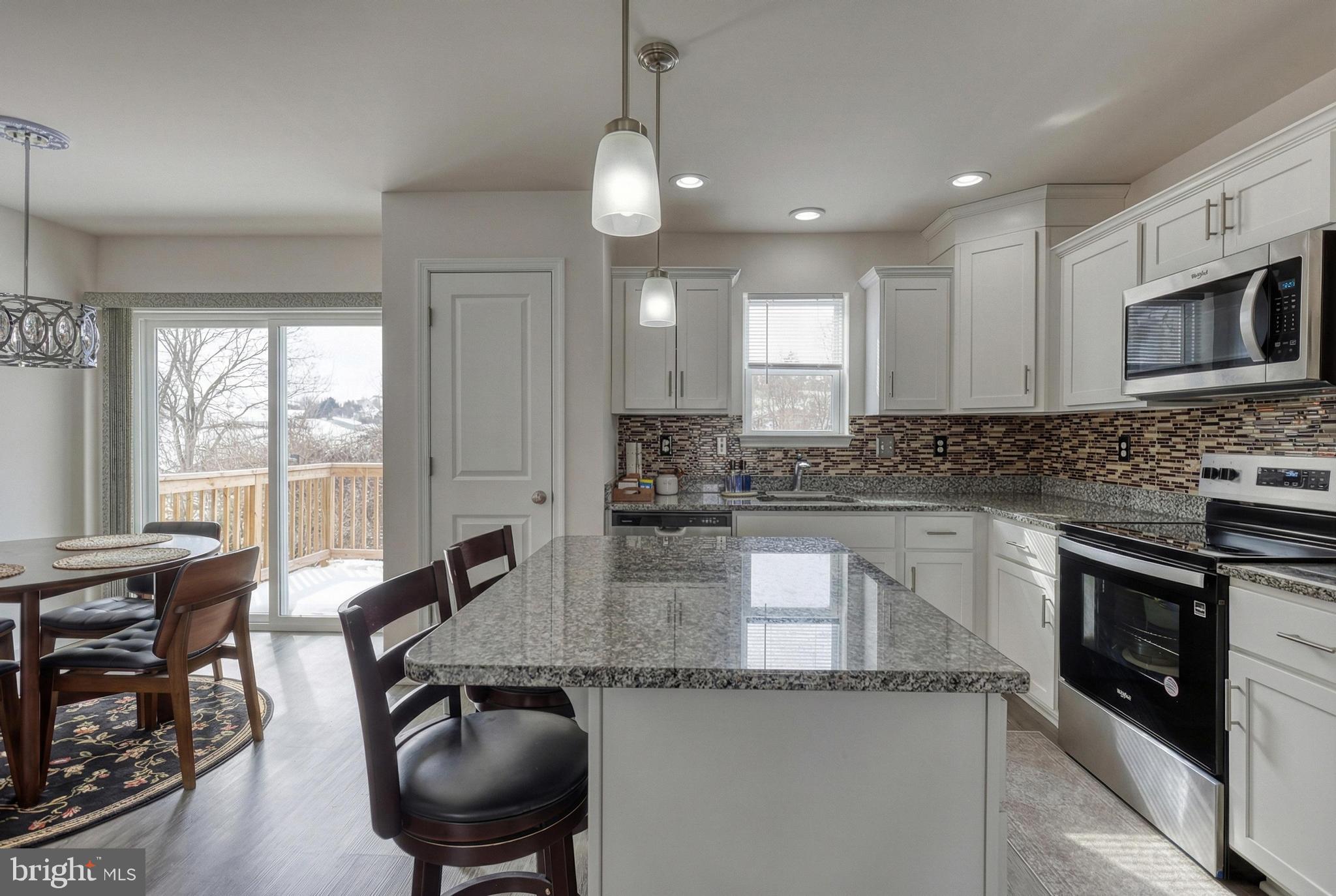 1 Landing Place, Unit 1 York, PA 17408 - Photo 11 of 48 a kitchen with stainless steel appliances granite countertop a stove a sink a microwave a dining table and chairs